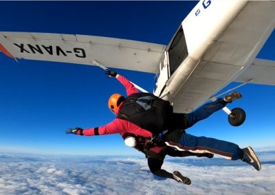 Tandem skydiver exiting the plane during charity skydive fundraiser - Salisburys
