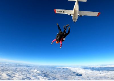 Tandem skydiver in freefall against blue sky during charity skydive fundraiser - Salisburys
