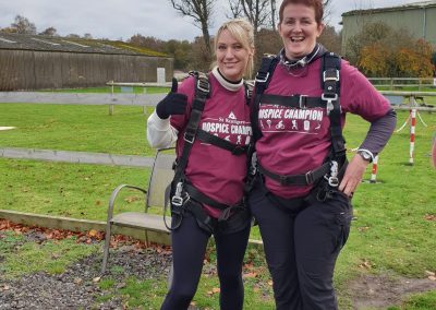 Two skydivers smiling after landing during a charity skydive fundraiser - Salisburys